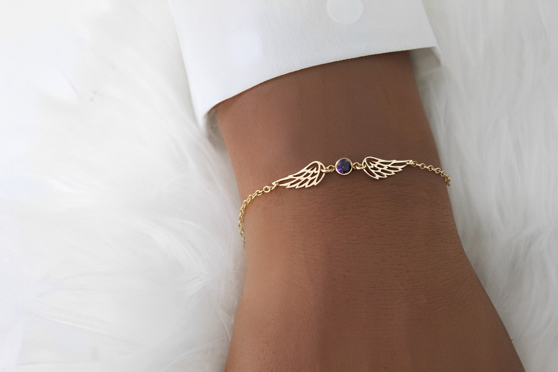 gold angel wing bracelet on the wrist