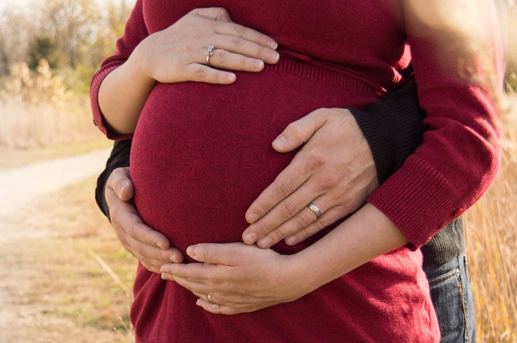 Man buying jewelry gift for her pregnant wife