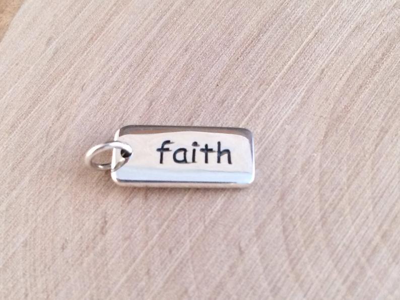 Charm with word faith on it