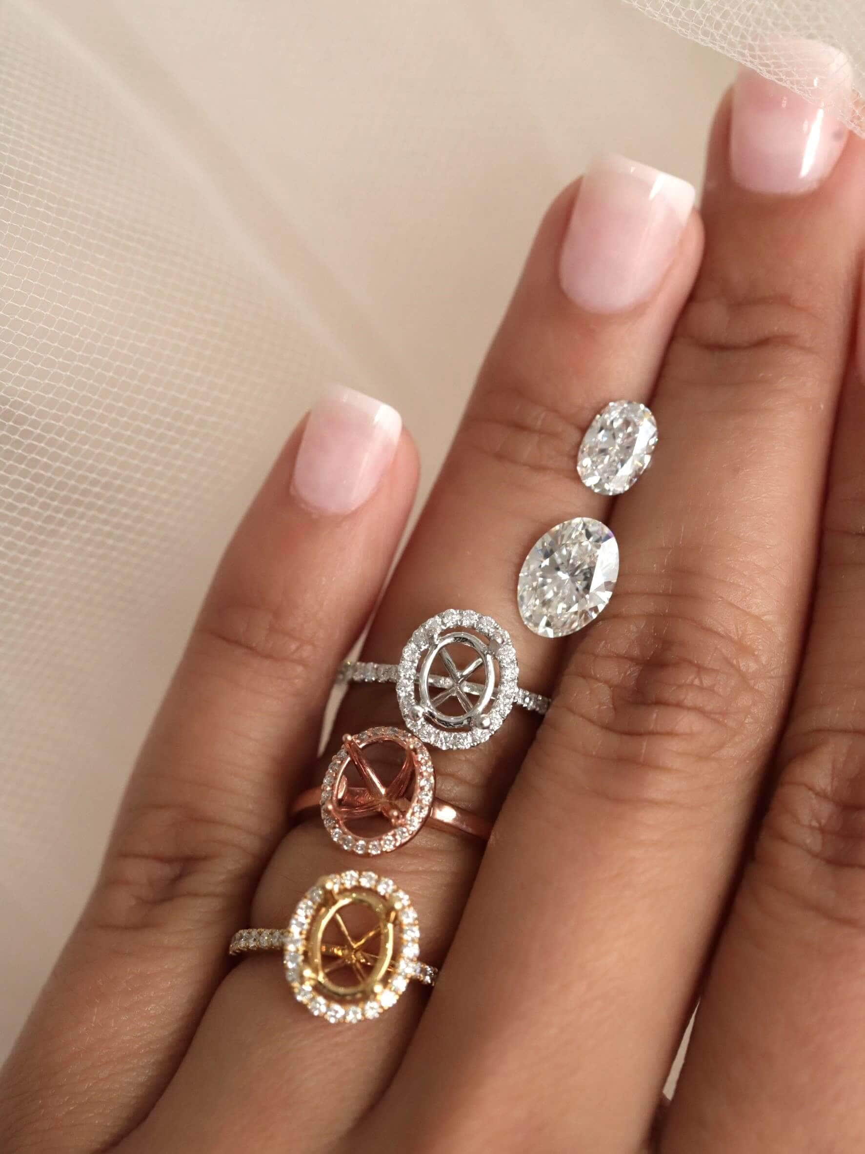 a hand with loose diamonds and ring settings