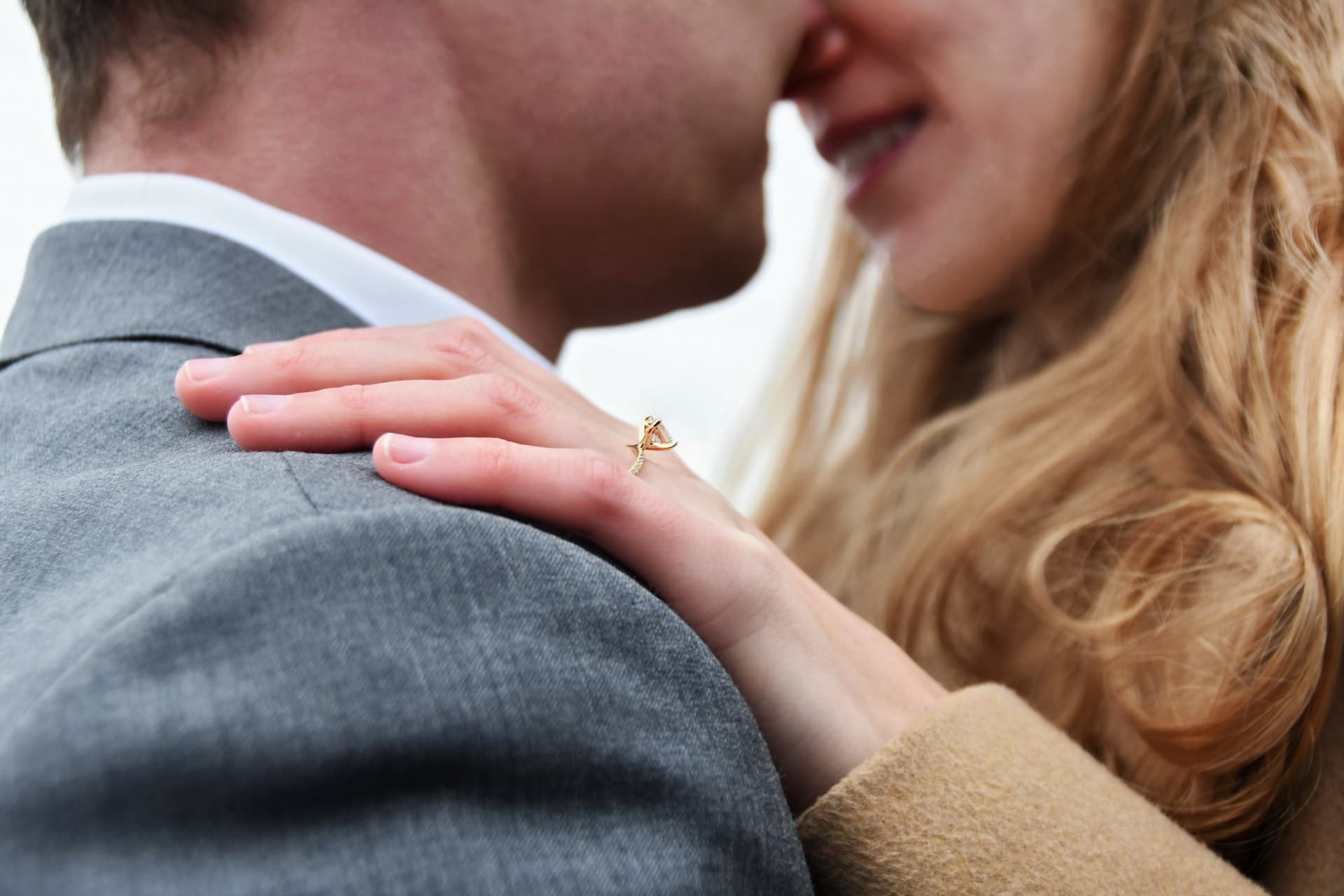 woman holding man on his shoulder with ring