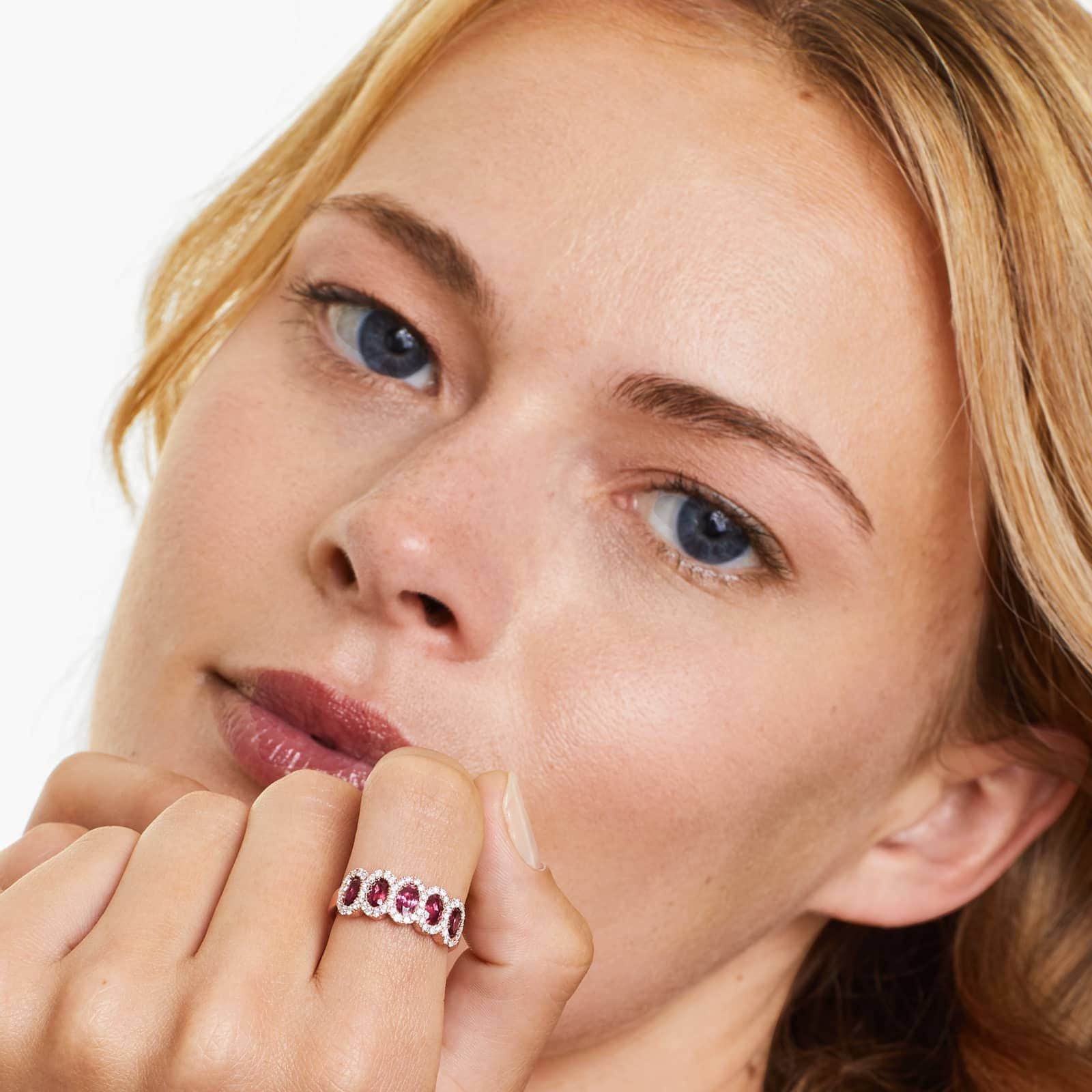 a woman wearing five stone ruby and diamond ring