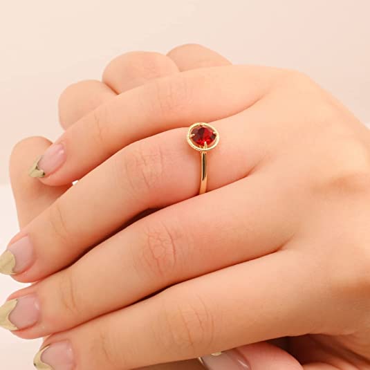 a hand with gold birthstone ring