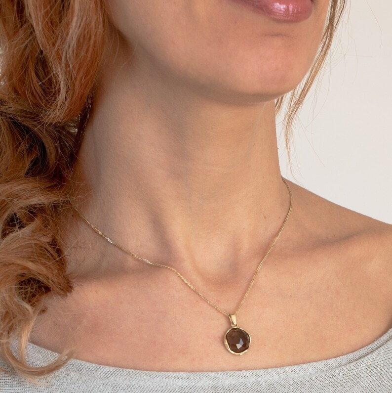 a woman wearing gold smoky quartz necklace