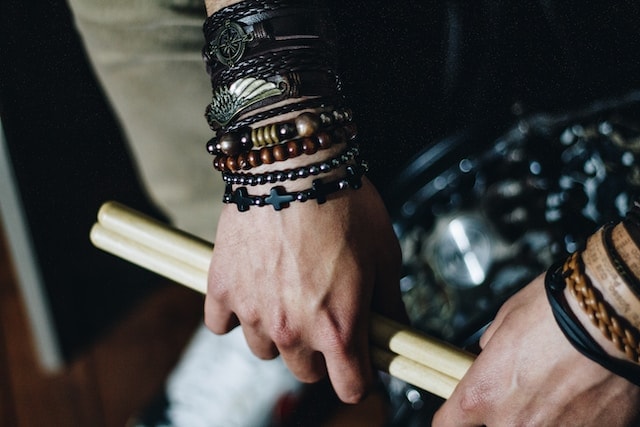 man wearing large bracelets of similar theme