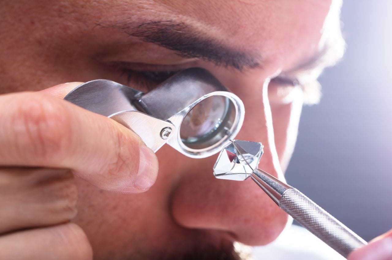 a jeweler using loupe to check the diamond