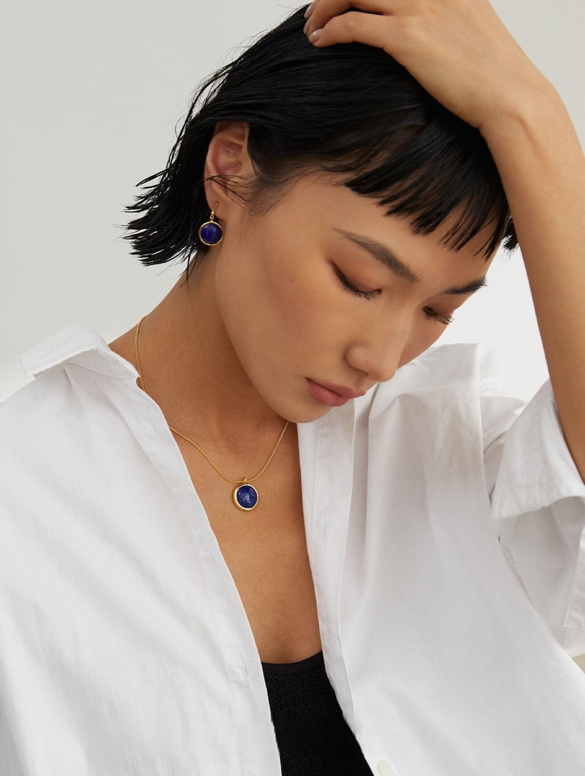 a woman wearing lapis lazuli drop earrings and necklace