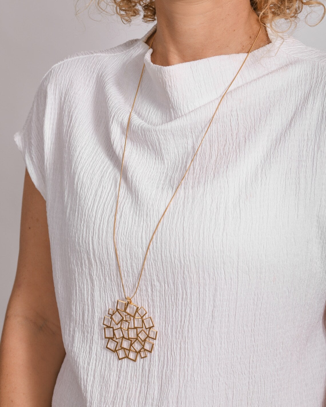gold pendant statement necklace on the woman's neck