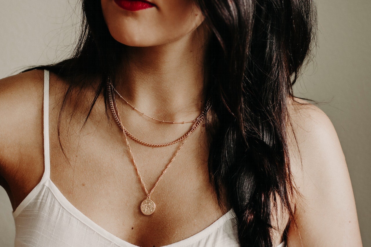 woman wearing layers of necklaces