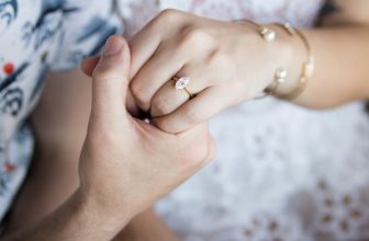 mans hand holding girls hand with marquise cut ring
