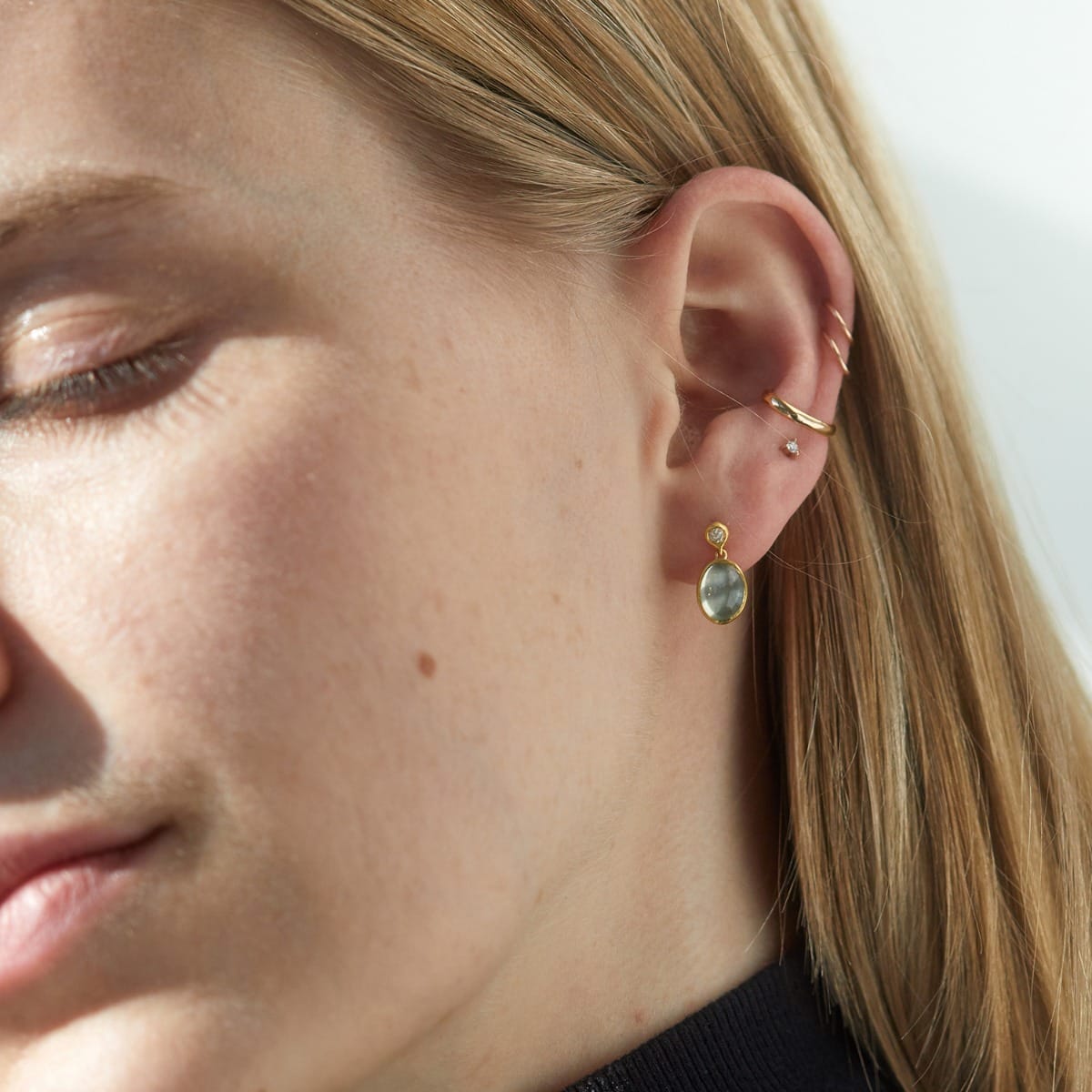a woman wearing moonlit mango moonstone earrings