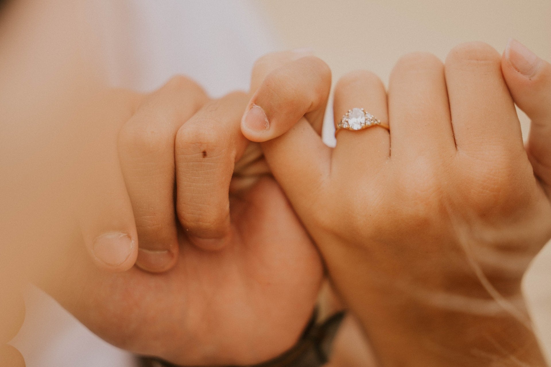 hands interlocked with diamond ring