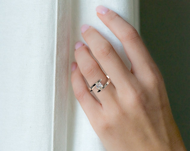 oval shape diamond in tension setting engagement ring on bride's finger
