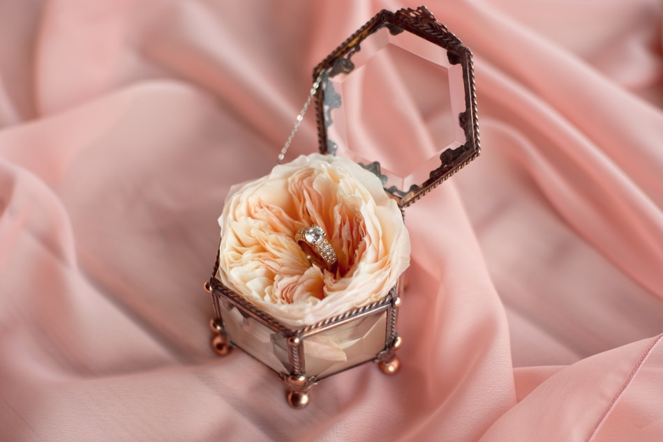 Rose gold engagement ring in a box pink background