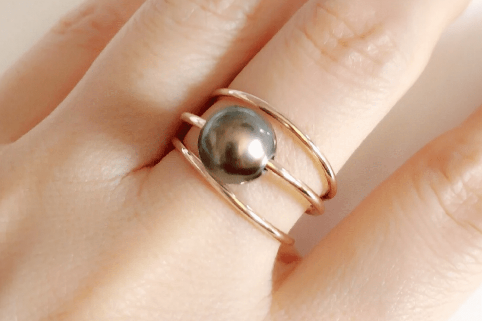 three ring black pearl earring on woman's hand