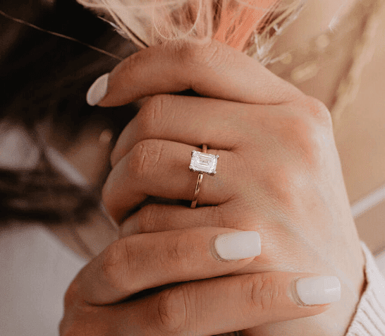 emerald cut diamond engagement ring on the woman's finger