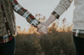 couple holding hands and wearing bracelet
