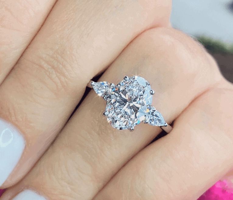 oval diamond engagement ring on the ring finger