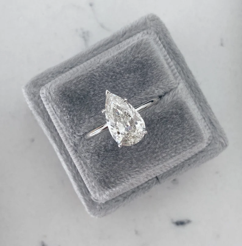 pear shaped diamond engagement ring on gray jewelry box