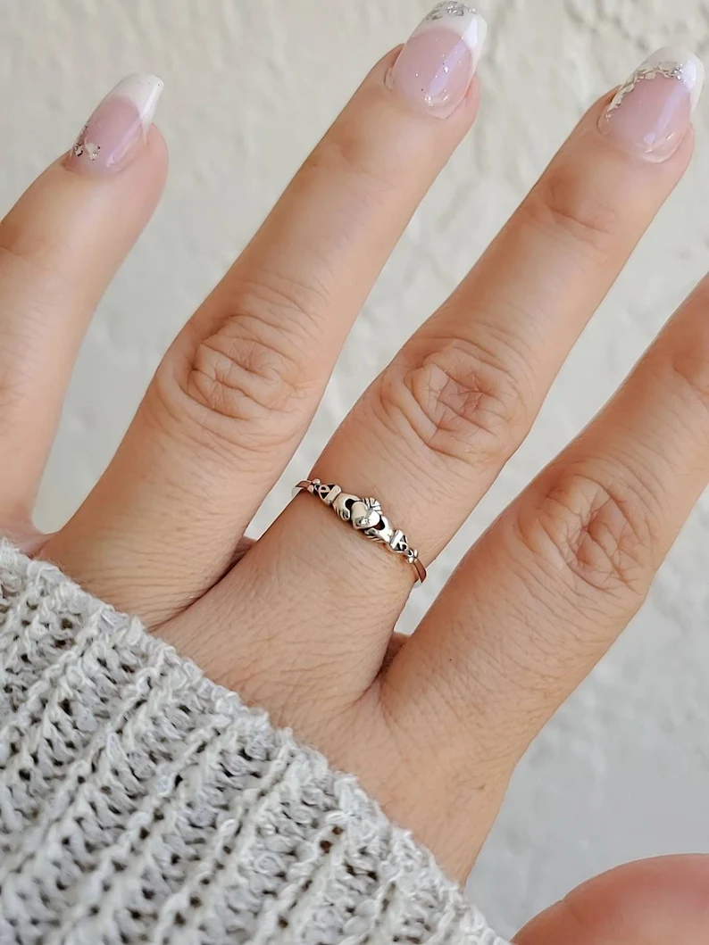 a hand with claddagh ring