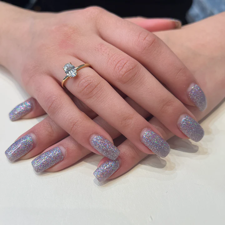 oval diamond engagement ring on the woman's ring finger