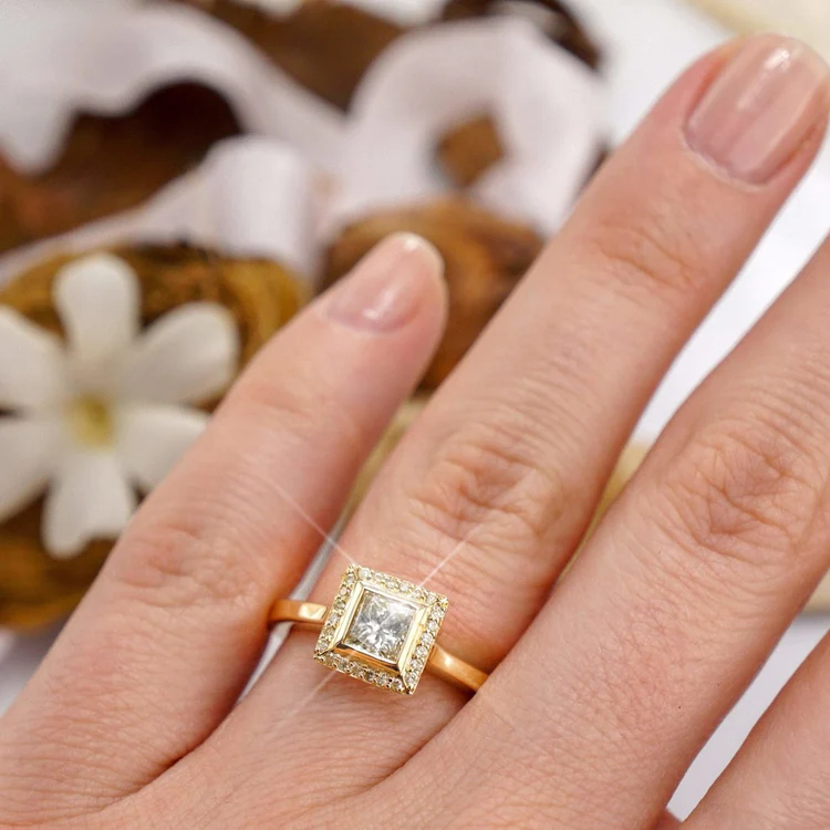 round and princess cut diamond engagement ring on the ring finger