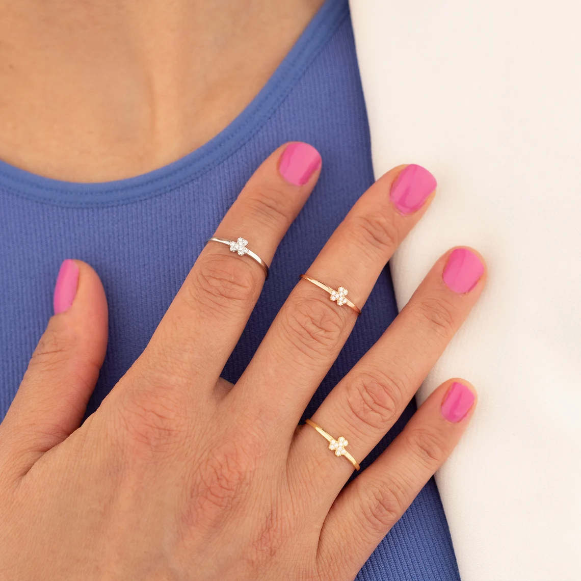 silver, yellow and rose gold shamrock rings on fingers
