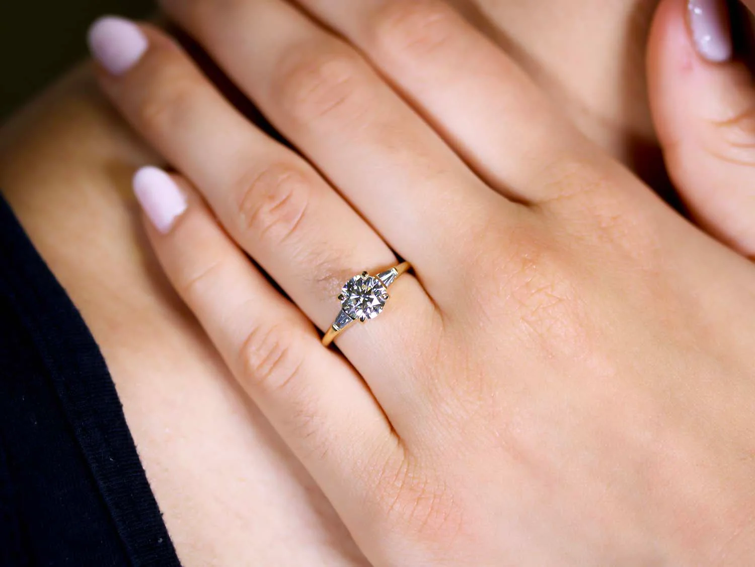 three stone engagement ring on the woman's ring finger