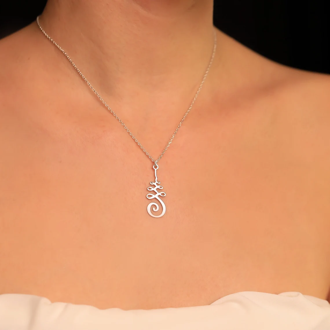 unalome silver necklace on the neck